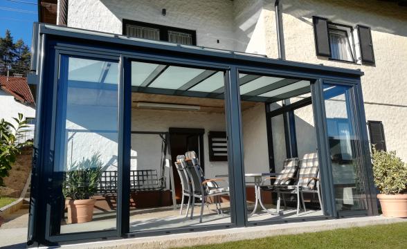 Sehr anspruchsvolles BAUMANN Glas Terrassendach mit Balkon grau mattweiß