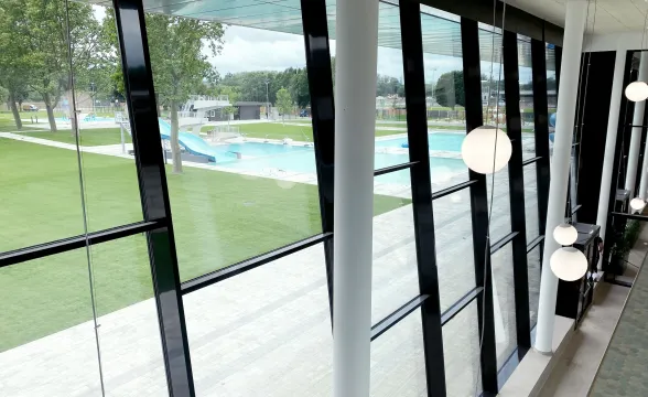 Tageslichtgeflutetes Hallenbad dank Posten-Riegel-Glasassade